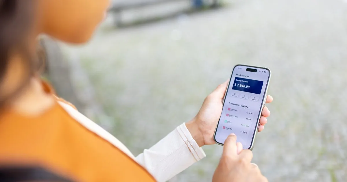 A person holding a smartphone with a banking app open