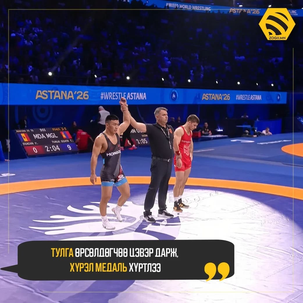 The referee raises T. Tulga's hand after his win over Moldova's Vasile Diacon. Image: Zogii.mn