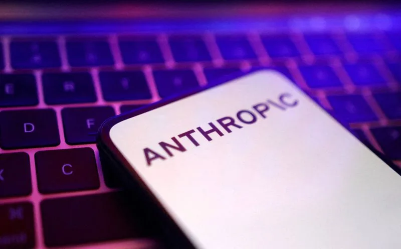 The Anthropic logo on a smartphone screen resting in front of a computer keyboard