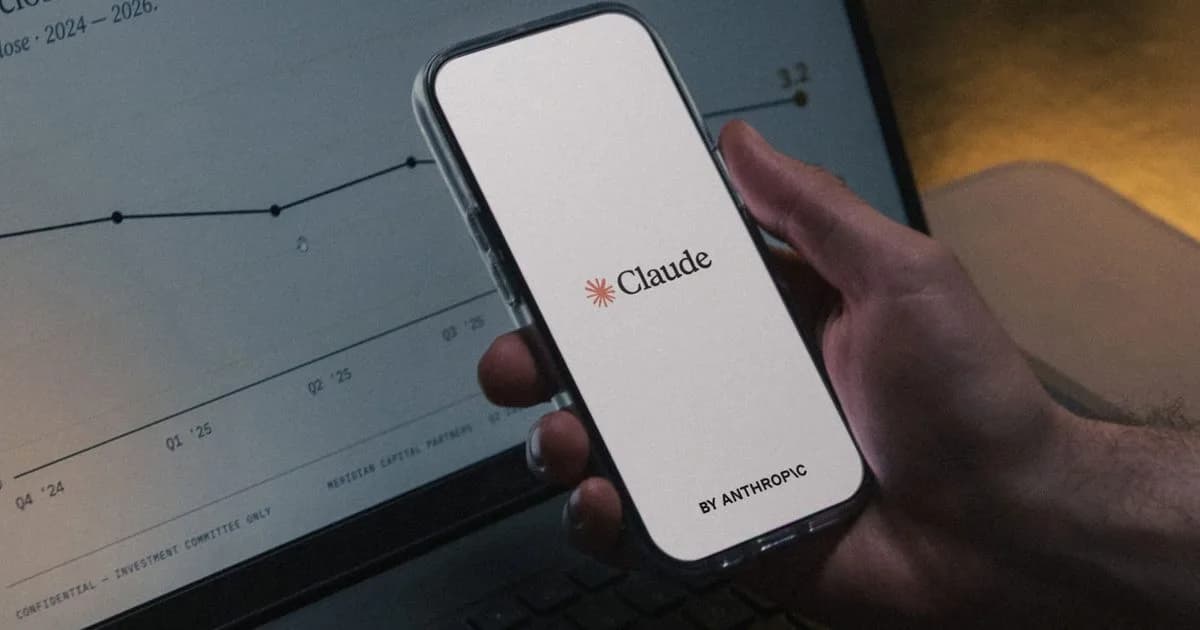 Smartphone showing the Claude app in front of a laptop displaying a chart